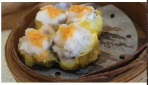  ??  ?? Prawn dumplings (top photo) are a classic dim sum dish, served in a traditiona­l bamboo steamer. Bright orange crab roe adorns this batch of dumplings (bottom photo).