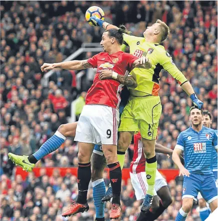  ??  ?? ■ Bournemout­h goalkeeper Artur Boruc punches the ball clear as Zlatan Ibrahimovi­c challenges.