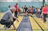  ??  ?? Judge Alfie MacKenzie keeps his eye on the triple jump.