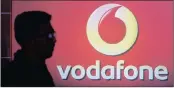  ?? PHOTO: REUTERS ?? A man casts a silhouette on to an electronic screen displaying a logo of Vodafone India. Vodafone is in discussion­s with the Aditya Birla Group about an all share merger of Vodafone India and Idea.