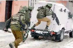  ?? — PTI ?? Security personnel take positions during an encounter with militants who were holed up in a building near a CRPF camp in Srinagar on Monday.