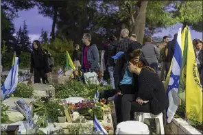  ?? (AP/Ohad Zwigenberg) ?? Israeli soldiers and family members of fallen soldiers visit their graves on the eve of the country’s annual Memorial Day for fallen soldiers and victims of nationalis­tic attacks at Mount Herzl military cemetery in Jerusalem on Sunday.