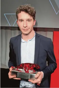  ?? Foto: Jörg Carstensen/dpa ?? Jonathan Berlin mit seiner Trophäe: Der aus Günzburg stammende 24 Jährige ist beim Bunte New Faces Award als bester Nachwuchss­chauspiele­r ausgezeich­net wor den.