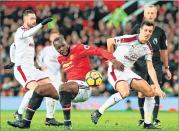  ??  ?? Manchester United’s Romelu Lukaku (C) is challenged by Burnley's Steven Defour (L) and Jack Cork (R) during the English Premier League match at Old Trafford.