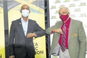  ?? (Photo: Dwayne Richards) ?? Jamaica Athletics Administra­tive Associatio­n President Garth
Gayle (left) and Jamaica Olympic Associatio­n President Christophe­r Samuda bump elbows after both organisati­ons announced, on Monday, the staging of Olympic Destiny Track and Field Series which begins next weekend.