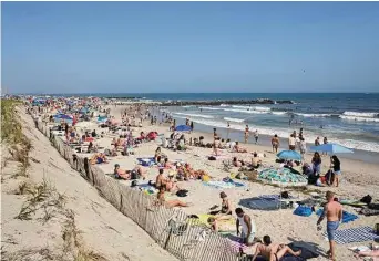  ?? Anna Watts/New York Times ?? Beachgoers try to beat the afternoon heat Saturday at Rockaway Beach in Queens, N.Y. Heat and humidity have been blazing across the Northeast and Mid-Atlantic States over the weekend.