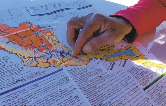  ?? TANIA NAVARRO U-T ?? Robert Connell, a Venezuelan migrant in transit in Tijuana, points to the map he used to travel across Central America and Mexico to get to the border with the U.S.