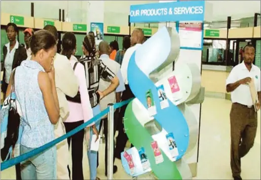  ??  ?? Customers transactin­g in a banking hall