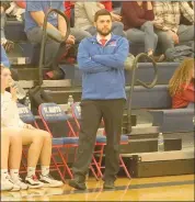  ?? Photos by Becky Polaski ?? New St. Marys Area Lady Dutch basketball head coach Zane Adiyeh is shown, at left, with his players during their season opener on Tuesday, and at right, watching the action on the court during the second half. The team’s 63-31 victory was Adiyeh’s first varsity win as a head coach.