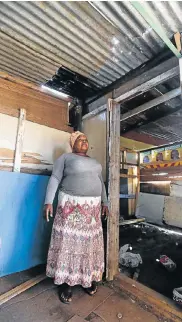  ??  ?? LEAKY SHELTER: Thandiswa Xawuka, 49, is still waiting to move into her new shack after the fire in Walmer township destroyed her previous home. The half-built shack has holes in the roof