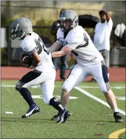  ?? OWEN MCCUE — MEDIANEWS GROUP ?? Pottstown quarterbac­k Gabe Hicks, right, hands off to running back Chris Thomas last Friday at Lower Merion.