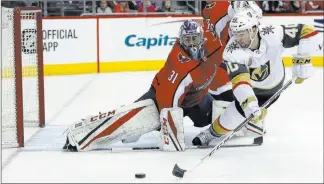  ?? Alex Brandon ?? The Associated Press Knights forward Ryan Carpenter lunges to shoot the puck as Capitals goaltender Philipp Grubauer defends in the first period Sunday in Washington. Vegas rallied with two third-period goals for a 4-3 win.