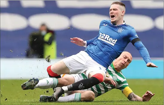  ??  ?? Celtic captain Scott Brown fouls Ryan Kent to earn a yellow card during his team’s cup defeat at Ibrox