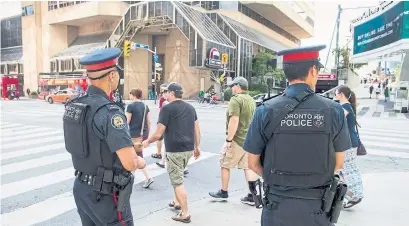  ?? CARLOS OSORIO/TORONTO STAR ?? While emphasizin­g that Torontonia­ns should go about their day as normal, police increased the number of officers downtown.