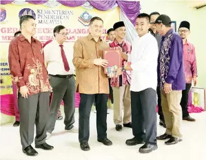  ??  ?? ARIFIN menyampaik­an anugerah pelajar cemerlanga­n kepada salah seorang pelajar sempena majlis itu.