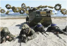  ??  ?? In this 2016 file photo, Marines of the U.S. (left) and South Korea wearing blue headbands on their helmets, take positions after landing on a beach during the joint military combined amphibious exercise. KIM JUN-BUM/YONHAP VIA AP
