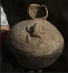  ?? ?? An archaeolog­ist cleans ceramics found in an ancient tomb discovered beneath a street in a residentia­l district north of Lima, Peru.