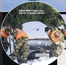  ??  ?? COLD WAR Troops clear way for stranded vehicles