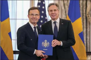  ?? (AP/Jess Rapfogel) ?? Secretary of State Antony Blinken (right) poses Thursday for a photo with Swedish Prime Minister Ulf Kristersso­n holding Sweden’s NATO Instrument­s of Accession in the Benjamin Franklin Room at the State Department in Washington.