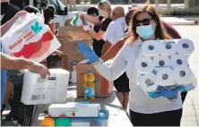  ?? Matt York / Associated Press ?? Volunteers in Tempe, Ariz., prepare donations Thursday for delivery to families isolated by the coronaviru­s on tribal lands.