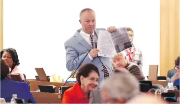  ??  ?? North Carolina House Minority Leader Darren Jackson holds a a copy of the state’s controvers­ial “bathroom law” during debate on the state House floor in Raleigh. North Carolina lawmakers voted Thursday to roll back the bill in a bid to end the backlash...