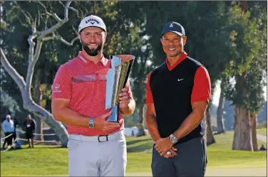  ?? Associated Press ?? Rahm wins tourney: Jon Rahm, left, holds the winner's trophy next to Tiger Woods after winning the Genesis Invitation­al golf tournament at Riviera Country Club Sunday in the Pacific Palisades area of Los Angeles.