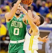  ?? Ezra Shaw / Getty Images ?? Boston’s Jayson Tatum looks to shoot against Stephen Curry of the Golden State Warriors. Tatum had 12 points for the Celtics; Curry led the Warriors with 34.