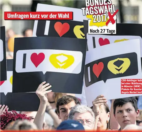  ??  ?? Umfragen kurz vor der Wahl Noch 27 Tage CDU-Anhänger halten bei einer Wahlkampft­our in Münster (NRW) Plakate für Kanzlerin Angela Merkel hoch.