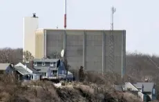  ?? Steven Senne, The Associated Press ?? A portion of the Pilgrim Nuclear Power Station is visible beyond houses along the coast of Cape Cod Bay, in Plymouth, Mass.