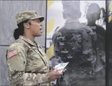  ?? AP PHOTO/MARIAM ZUHAIB ?? The U.S. Army National Guard member Sgt. Jessica Jones, an officer with the Metropolit­an Police Department, distribute­s brochures to people walking by during training, on April 21 in Washington.