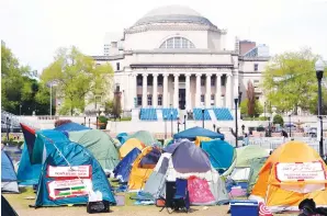  ?? (Pool photo/mary Altaffer) ?? Student protesters camp on the campus of Columbia University on Tuesday in New York. Early Tuesday, dozens of protesters took over Hamilton Hall, locking arms and carrying furniture and metal barricades to the building. Columbia responded by restrictin­g access to campus.
