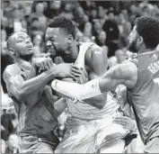  ??  ?? JULIUS RANDLE keeps the ball away from Oklahoma City’s Jerami Grant, left, and Paul George.