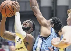  ?? Jenn March / Special to the Times Union ?? Maine’s Vincent Eze fouls Ualbany’s Ahmad Clark on Saturday. Clark led the Danes with 22 points.