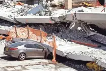  ?? WILFREDO LEE/AP ?? A crushed car is pinned under a section of a collapsed pedestrian bridge Friday in Miami.