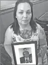  ?? Associated Press ?? Angela Williams last month holds a photo of her 18-year-old son, Cameron D. Pugh, who was killed as part of a murder spree that hit Louisville, Ky., in 2016. Two months before his death, Williams and Pugh were among the throngs paying tribute to...