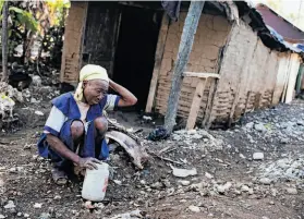  ?? David Rochkind / New York Times ?? Janelia Point Dujour sits outside her home damaged by Hurricane Sandy. Haiti, still struggling to recover from the 2010 earthquake, also faces a food crisis.