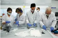  ?? (Amir Cohen/Reuters) ?? SONOVIA EMPLOYEES work at their laboratory in Ramat Gan last month.