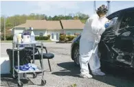  ?? STAFF PHOTO BY WYATT MASSEY ?? Christy Botts, clinical manager at Physicians Services, swabs someone for a COVID-19 test in the parking lot of the Cleveland, Tenn., clinic on March 29.