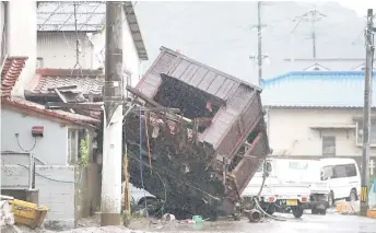  ??  ?? A building structure washed away by flooding due to torrential rain is seen on a street in Hitoyoshi, Kumamoto prefecture.