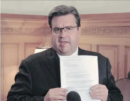  ?? JOHN KENNEY/MONTREAL GAZETTE ?? Mayor Denis Coderre holds up an email at a news conference on Wednesday, after Environmen­t Canada gave its ruling on the city of Montreal’s plan to dump 8 billion litres of raw sewage into the St. Lawrence River.