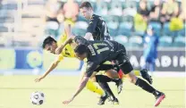  ?? PHOTO: GETTY IMAGES ?? Brought down . . . Ulises Davila, of the Phoenix, is fouled by Keanu Baccus (front), of the Western Sydney Wanderers, during the sides’ ALeague match at WIN Stadium, Wollongong, yesterday.