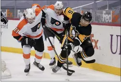  ?? KEITH SRAKOCIC - THE ASSOCIATED PRESS ?? Pittsburgh Penguins defenseman Mike Matheson, right, tries to control the puck as the Flyers’ Travis Konecny, left, and Connor Bunnaman pursue during the second period Tuesday night in Pittsburgh.