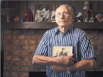  ?? ROBERTO E. ROSALES/JOURNAL ?? Holocaust survivor Andy Holten holds a picture in his Northeast Albuquerqu­e home of him and the Christian couple, Johannes and Nel Meijer, who sheltered him during World War II. He was the only member of his family that survived.