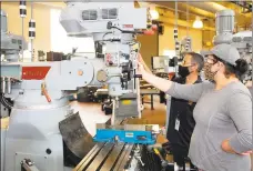  ?? Contribute­d photo ?? Jackie Valcarcel works with instructor Louis Roettger on a milling machine at Eli Whitney Technical High School as part of Skill Up for Manufactur­ing.