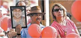  ?? GUSTAVO ANDRADE/AP ?? A man holds a portrait of a victim who died in the 2019 dam disaster last year in Brumadinho city, Minas Gerais state, Brazil. On Saturday, relatives of victims had a memorial.