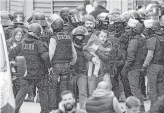  ?? Peter Dejong / Associated Press ?? Residents are evacuated in St. Denis, France, where a woman wearing an explosive suicide vest blew herself up Wednesday during a police raid of an apartment in the Paris suburb.