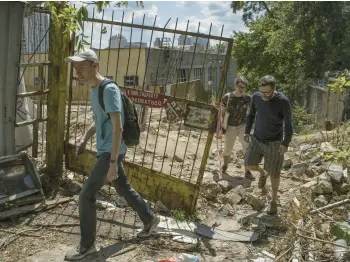  ?? LAURA BOUSHNAK/THE NEW YORK TIMES ?? Ihor Sumliennyi, left, and friends search for Russian war debris July 16 in Kyiv, Ukraine.