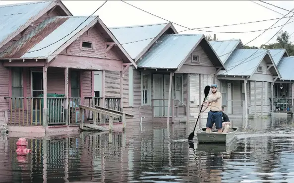  ?? SCOTT OLSON/GETTY IMAGES ?? Marine veteran Rocky Damico searches for residents in need of help after Harvey’s torrential rains caused widespread flooding on Saturday in Orange, Texas. The devastatio­n has sparked a debate over the climate and the need for tighter homebuildi­ng...