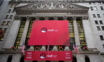  ?? | MICHAEL NAGLE Bloomberg ?? RED HAT signage is displayed outside of the New York Stock Exchange in New York. The deal is aimed at catapultin­g IBM into the ranks of its top cloud software competitor­s.