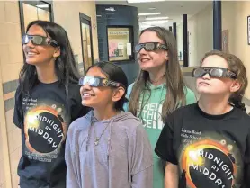  ?? PROVIDED PHOTO ?? From left to right, cast and orchestra members Misha Saxena, Abiah Joseph, Rebecca Refermat and Addison Bryant wear Midnight at Midday eclipse glasses. The Calkins Road Drama Club is selling these ISO-certified glasses for $3 before performanc­es and during intermissi­on.